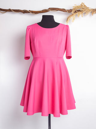 Front view of the Rose Dress by Cori Tailor in vibrant pink – 1950s-inspired fit-and-flare design with half sleeves and a full circle skirt, crafted for playful elegance.