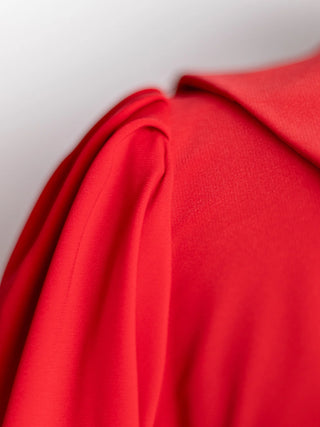 Close-up of the Sophia Dress in vibrant red, highlighting puff shoulder pleats and Peter Pan collar – part of a bold hero contrast on Cori Tailor's homepage.